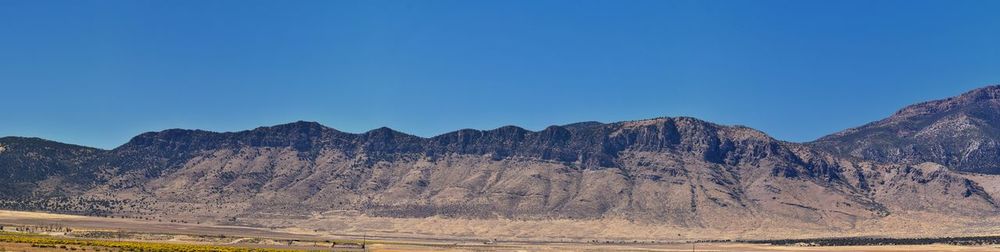 Scenic view of mountains against clear blue sky