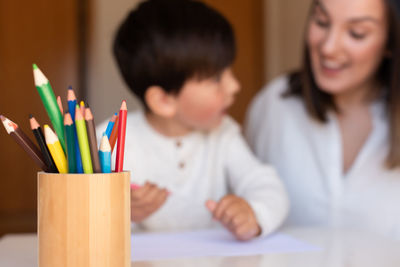 Smiling mother assisting son in drawing