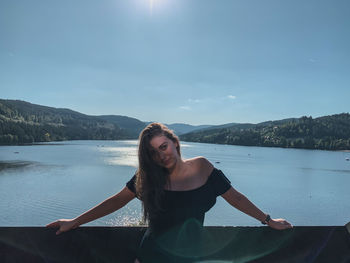 Portrait of young woman against sky