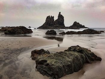 Rocks on beach against sky