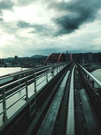 Railway bridge in city against sky