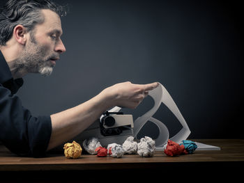 Man using typewriter on table over gray background