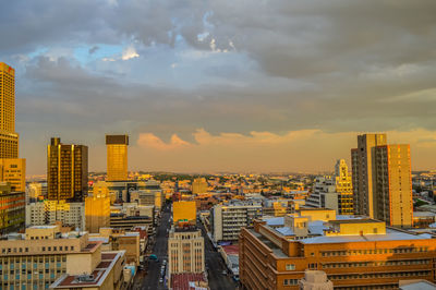 Buildings in city against sky during sunset