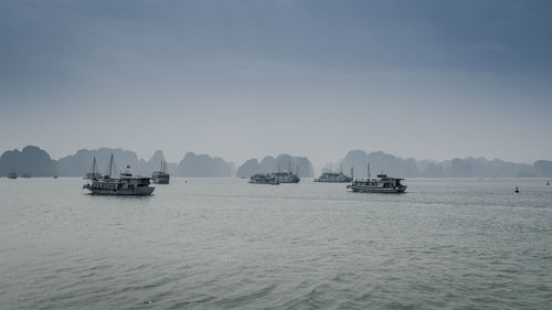 Boats sailing in sea against sky