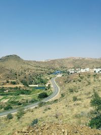 High angle view of winding road on landscape against clear sky