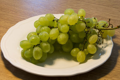 High angle view of grapes in plate on table