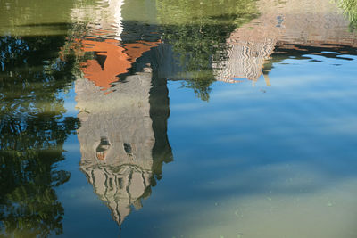 Reflection of medieval city wall with tower on moat