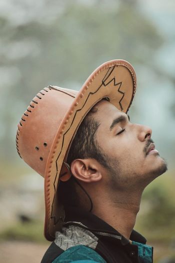 Young man with closed eyes wearing hat