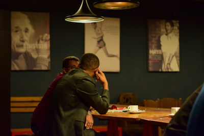Rear view of man standing at table