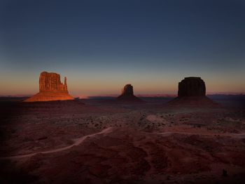 Scenic view of rock formations in desert against sunset