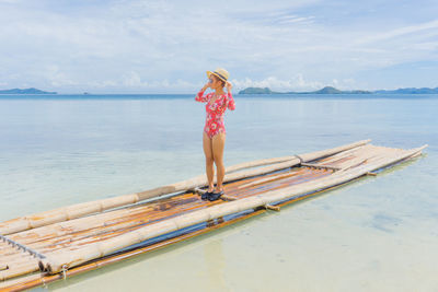 Rear view of woman on boat in sea against sky