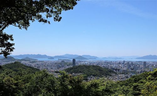 Scenic view of cityscape against clear blue sky