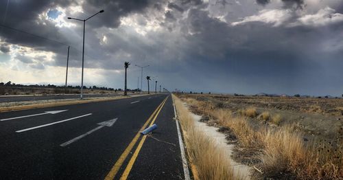 Road amidst field against sky