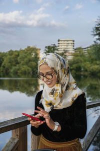 Smiling young woman using cell phone