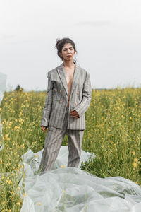 An asian model poses in a field of yellow flowers for a clothing brand, polyethylene