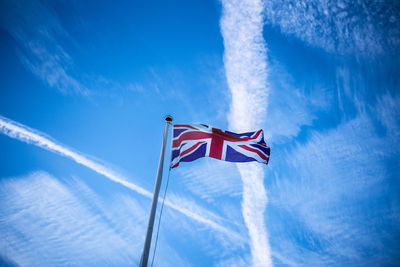 Low angle view of flag against blue sky