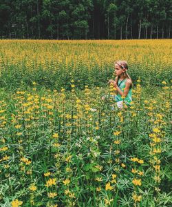 Girl looking away on yellow flowering field