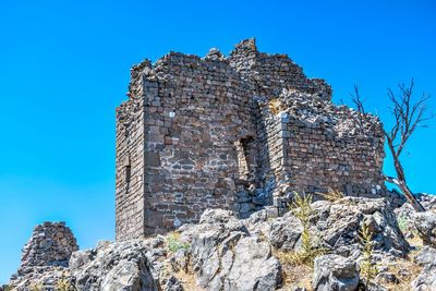 Low angle view of old building against clear blue sky