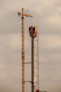 Low angle view of crane against sky