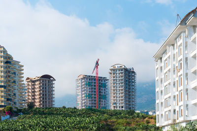 New monolithic apartment buildings under construction and construction crane.