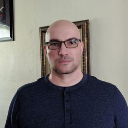 Portrait of young man standing against wall