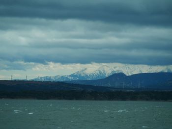 Scenic view of lake by mountains against sky