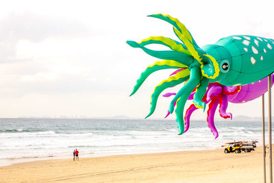 Boy with toy on beach against sky