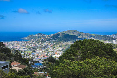 High angle view of townscape by sea against blue sky