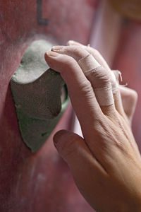 Close up of hand holding on to handhold at indoor climbing gym