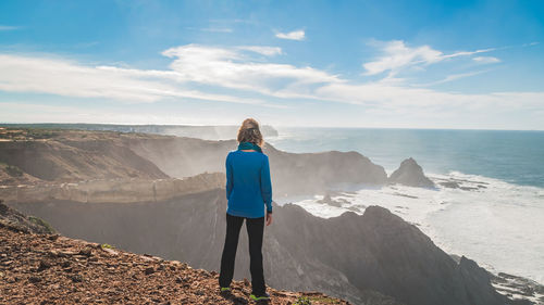 Rear view of woman looking at view of landscape