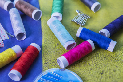 High angle view of colorful sewing items on fabric