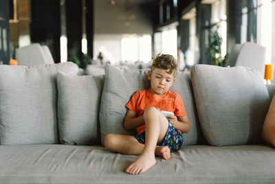 Young woman sitting on sofa at home