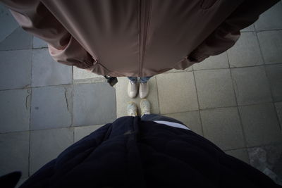 Low section of person standing on tiled floor