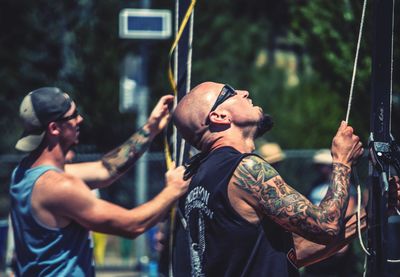 Man holding rope with arms outstretched