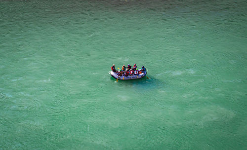 Raft boat with people at the middle of ganges river from top angle
