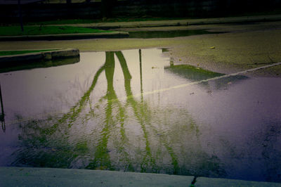 Reflection of man in puddle on street