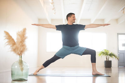 A guy in warrior 2 pose during yoga.