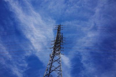 Low angle view of electricity pylon against cloudy sky
