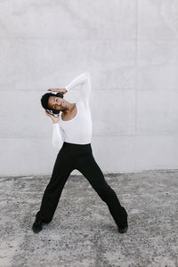 Young woman standing against wall