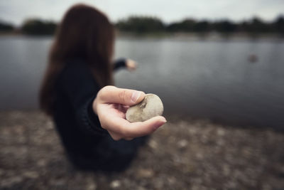 Rear view of woman holding seashell