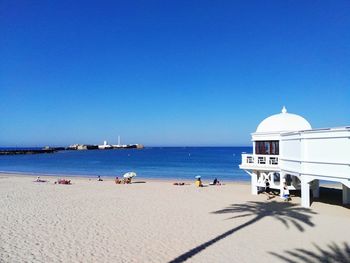 Scenic view of beach against clear blue sky