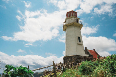 Low angle view of lighthouse amidst buildings against sky