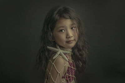 Portrait of a girl against black background