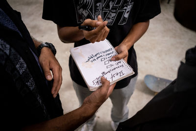 Midsection of man holding paper