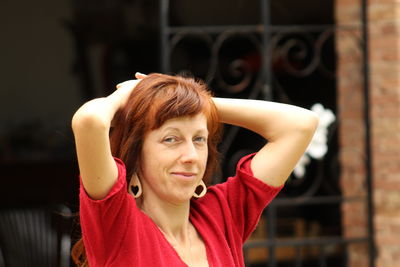 Portrait of young woman standing against wall