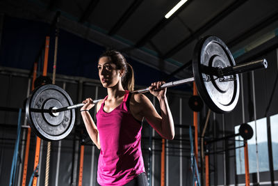 Portrait of young woman exercising in gym