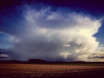 Scenic view of field against cloudy sky