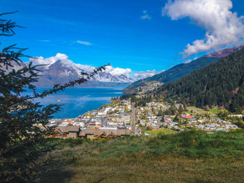 Scenic view of townscape and mountains against blue sky