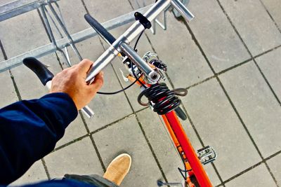 Low section of man working on bicycle