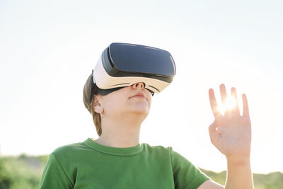 Portrait of man using mobile phone against clear sky